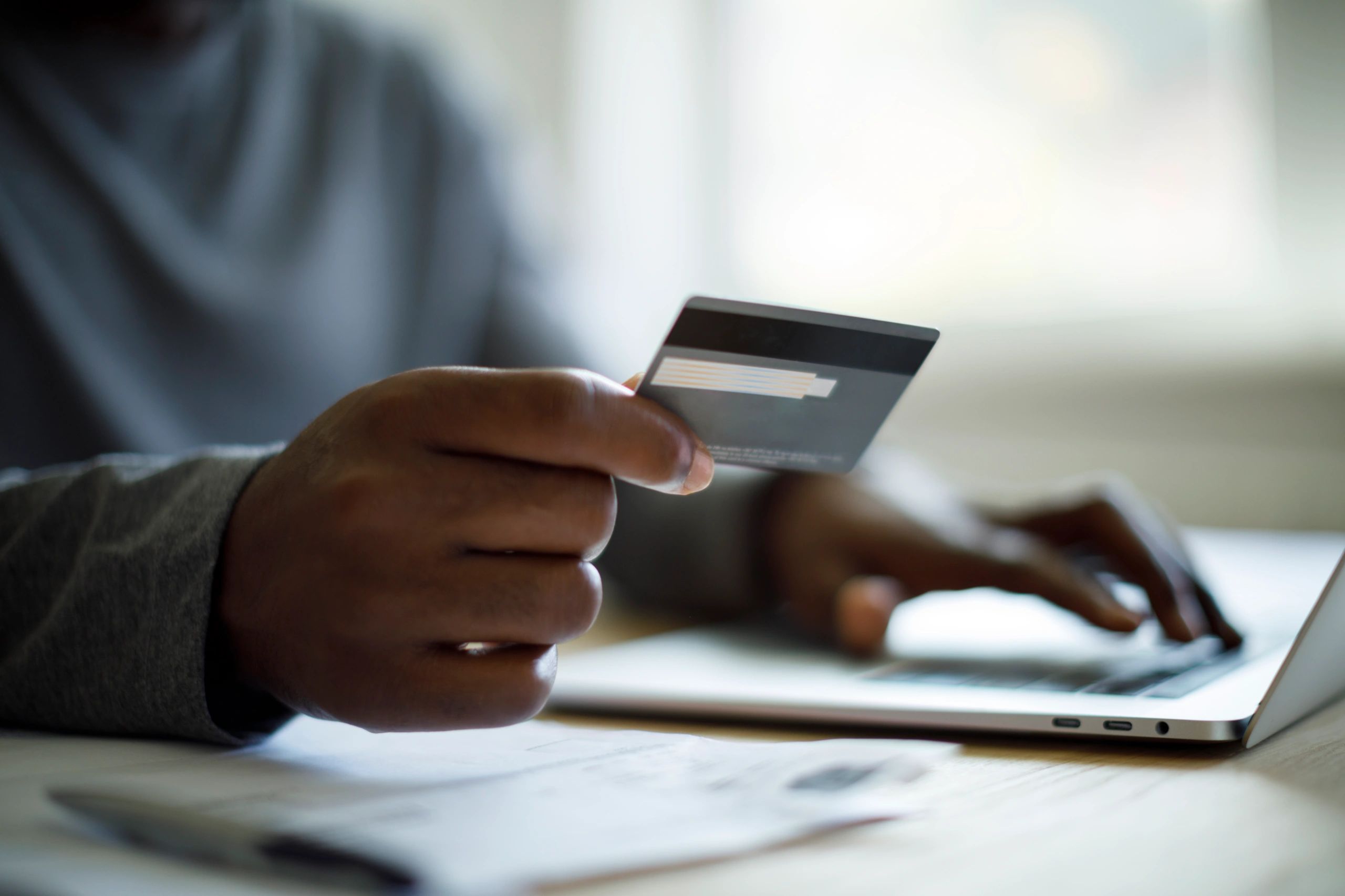 Customer shopping online with a laptop and credit card
