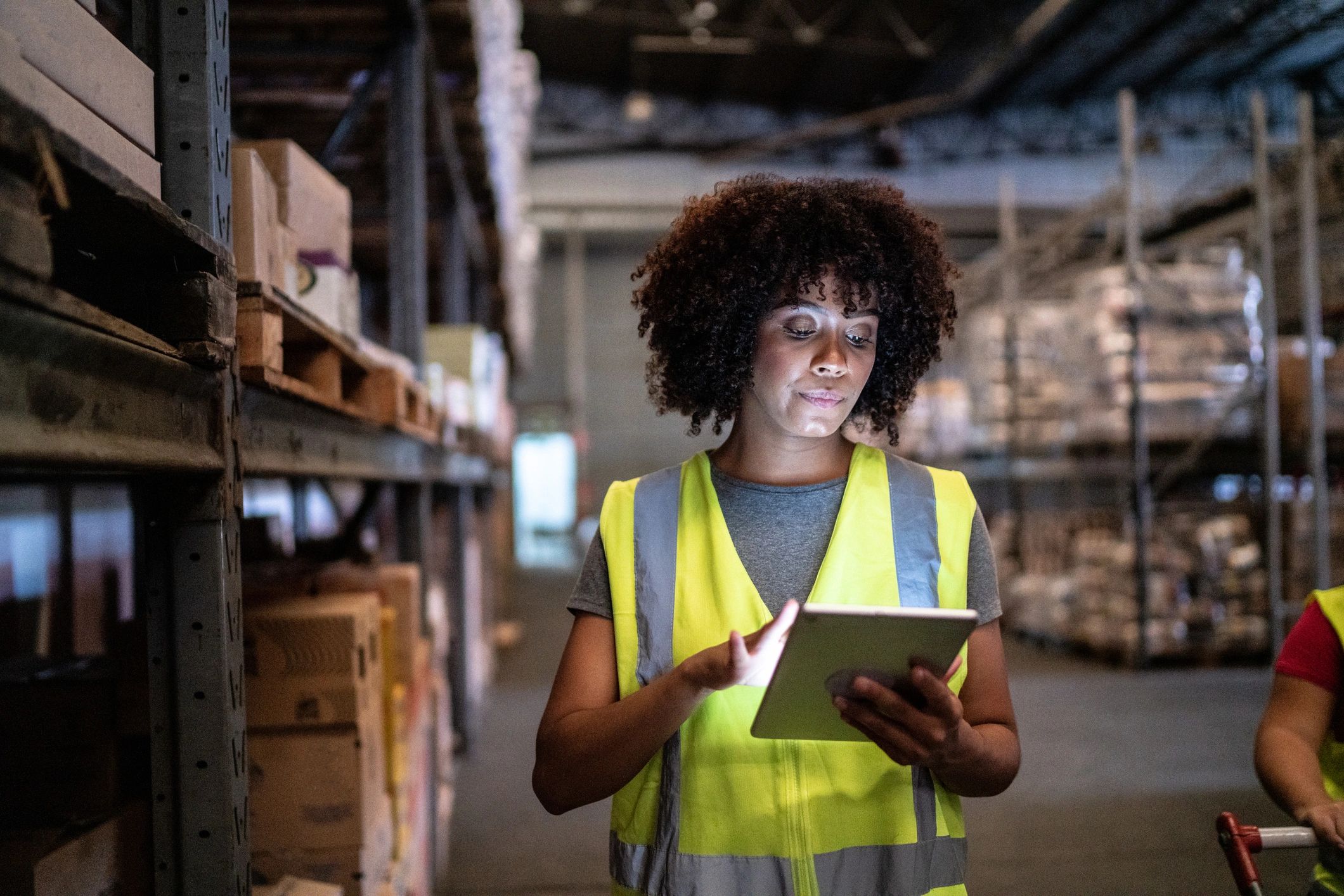 Warehouse team member performing a quality check with a tablet